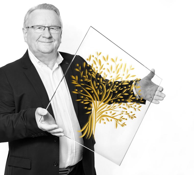 Pierre Riou, fondateur de Pierre & CRISTAL, tenant une plaque de verre gravée d'un arbre doré